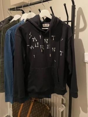 Saint Laurent Hoodie - Säljer nu denna saint Laurent hoodie (intressekoll). Väldigt bra skicka 9/10 och helt felfri. Väldigt unik och snygg hoodie och funkar för de mesta till allt. Bara komma med bud vid intresse. 🔥Bara höra av sig i dm vid frågor och funderingar!🔥(Bild med den på kan visas i dm)‼️