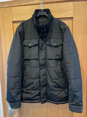 J.Lindeberg Bailey Field jacka (XL) - Snygg och stilren J.Lindeberg Bailey Field jacka, storlek XL. En tidlös field-/vinterjacka som funkar lika bra till vardags som mer uppklätt. Varm och bekväm med klassisk passform och hög krage som skyddar mot kyla och vind.  Jackan är i mycket bra skick, utan hål, fläckar eller andra skador. Bröstfickor med knäppning samt dragkedjefickor framtill ger både stil och funktion.  💰 Nypris: ca 4 500 kr 📏 Storlek: XL 📦 Skick: Mycket bra  Skickas snabbt!