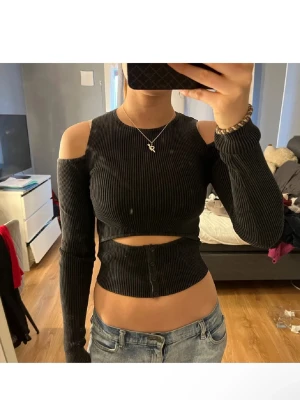 Svart ribbad croppad topp - Trendig svart ribbad croppad topp med cut-out detaljer vid axlarna och magen.Toppen är från Zara