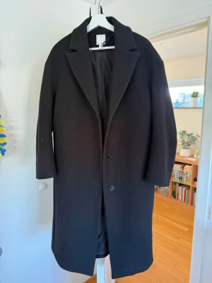Svart långkappa  - En svart långkappa från H&M i tjock material som funkar perfekt under vintern, hösten och våren!