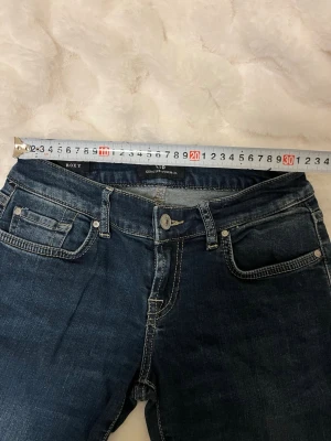 Ltb Jeans Roxy - Snygga mörkblå jeans från LTB med klassisk femficksdesign och kontrastsömmar. Jeansen har låg midja och raka ben. Materialet är denim med lätt tvättade detaljer för en cool look. Perfekta för dig som gillar en tidlös stil.