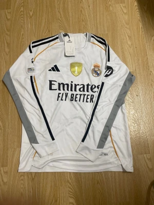 Real Madrid långärmad matchtröja - Säljer en vit långärmad Real Madrid matchtröja.Tröjan är i storlek M och aldrig använd.