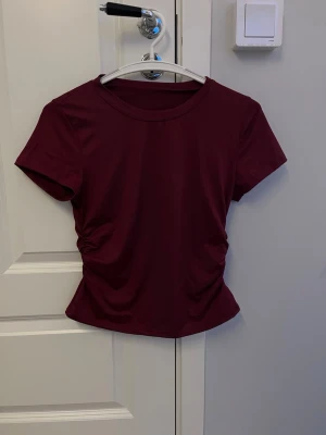 Röd t-shirt - Jättefin röd tröja med indragning på sidorna. Storlek S, aldrig använd.