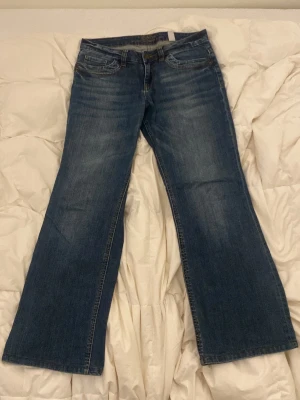 Bootcut jeans från S.Oliver - Säljer ett par klassiska blå bootcut jeans från S.Oliver. Jeansen har fem fickor, normal midja och är tillverkade i slitstark denim. Perfekta för dig som gillar en tidlös och avslappnad stil.