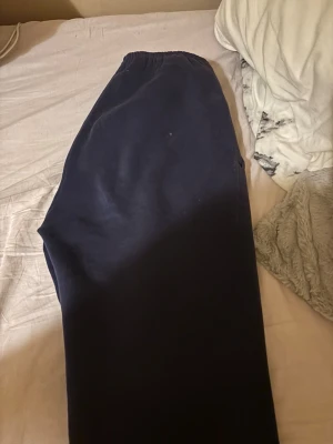 Mörkblå mjukisbyxor från Gina Tricot - Mörkblå mjukisbyxor från Gina Tricot med resår i midjan. Tillverkade i mjukt och skönt material, perfekta för chill dagar. Klassisk rak passform och enkel design utan synliga detaljer eller tryck.