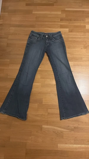 Mörkblå bootcut jeans R.MARKS - Säljer ett par vintage mörkblå bootcut jeans från R.MARKS med klassisk femficksdesign och låg midja. Jeansen har breda utsvängda ben och en snygg tvätt. Storlek 26/33. Midjemått: 37 cm (rakt över). Benmått: 97 cm. Innerbensmått: 79 cm.  