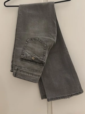 Gråa bootcut jeans low waist  - Säljer ett par low waist jeans från Gina young. Dom är aldrig använda då jag köpte i fel storlek men jätte fina. Dom är både low waist och bootcut❣️ ljuset på bilderna gör så att dom ser lite mörkare ut än vad dom igentligen är.
