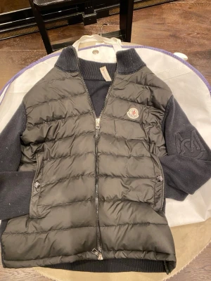 Moncler cardigan - Säljer nu denna riktigt feta moncler cardigan för den börjar bli för liten. Priset är så billigt därför att moncler märket inne i jackan är halvt trasig ( se bild Nmr 1) och för att jackan troligtvis har krympt i tvätten utav tidigare ägare. Köpte den på Vinted för cirka ett halvår sedan. Storleken står att det är m men den passar som cs på tjejer typ och mellan 157-170 typ på killar. Kom med bud eftersom priset verkligen kan diskuteras eller bara om ni vill se mer bilder eller fråga något!