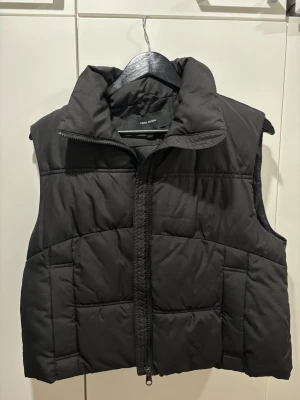 Svart dunväst från Vero Moda - Stilren svart väst från Vero Moda. 