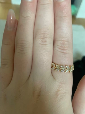 Guldfärgad bladformad ring - Säljer en snygg guldfärgad ring med bladformad design. Ringen har öppna detaljer och är tillverkad i metall med en glansig finish. Perfekt accessoar för att lyfta din stil med en trendig och unik touch.