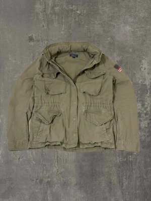 Ralp Lauren field jacket - En extremt stillren grön Ralph Lauren field jacket i super bra skick! Den är i storlek M, men är mer som S! Passar väldigt bra med allt, och har dessutom en luva som går at fälla ut!  Obs, jackan har några väldigt små fläckar på ryggen som syns i sista bilden.   Meddela gärna oss om du har några frågor, priset är ej hugget i sten vid snabb affär!   Mvh Saint ;)
