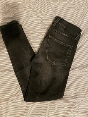 Replay bronny - Snygga svarta skinny jeans med lätt slitna detaljer och klassisk femficksdesign. Jeansen har en smal passform och normalhög midja. Perfekta för dig som gillar en stilren och trendig look. Storlek w28 L30 