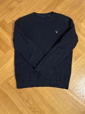 Mörkblå kabelstickad tröja från GANT - Klassisk kabelstickad tröja från Gant i storlek L. 🔥 Tröjan är som ny och har inga tecken på användning. Skick 9/10, pris är inte hugget i sten. Hör av er vid intresse!😎🔥