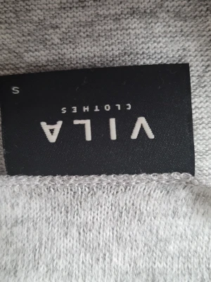 Ljusgrå topp från Vila - Säljer en enkel och stilren ljusgrå topp från Vila. Toppen är i mjukt material och har en clean look utan detaljer eller mönster. Perfekt att matcha med jeans eller kjol för en avslappnad vibe.