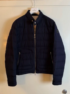 Moncler cashmere Acorus  - Moncler navy blue cashmere Acorus. Ny säsong 2025. Slutsåld i butik för 21,000kr skicket som nytt med plast kvar på zipper. Pris 6490kr finns att köpa på våran hemsida, Fashionels.com
