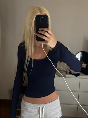 Mörkblå långärmad topp - Snygg mörkblå långärmad topp med tight passform och rundad halsringning. Perfekt att styla med jeans eller kjol för en trendig look. Enkel och stilren design utan synliga detaljer eller mönster. xxs eller xs lite osäker 