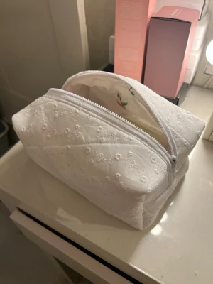 Vit necessär - Söt vit necessär med super gulligt mönster! Perfekt för att förvara smink eller skönhetsprodukter och är super rymlig. Helt ny aldrig använd🤍🤍