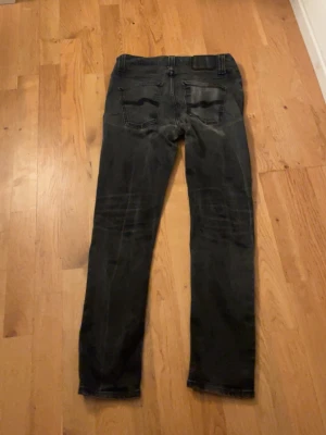 Svarta nudie jeans - Säljer ett par svarta nudie jeans i storleken W29 L32. De är i bra skick och har inga defekter. Det är bara att hör av sig vid minsta fundering🙌