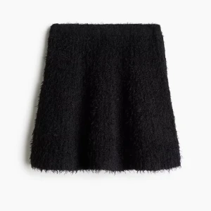 Svart fluffig kortkjol med matchande tröja. Set från H&M - Säljer en svart fluffig kortkjol med mjuk och lurvig textur. Kjolen har en A-linjeformad siluett och är perfekt för dig som vill ha en trendig och mysig look. Kommer med en matchande tröja.  Passar till både stickade tröjor och coola boots. Kjolen: Xs, Tröjan: S. Aldrig använt. 