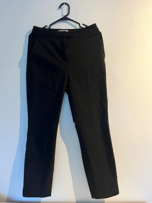 Svarta kostymbyxor med rak passform - Snygga svarta kostymbyxor med rak passform och klassisk midja. Storlek: 34