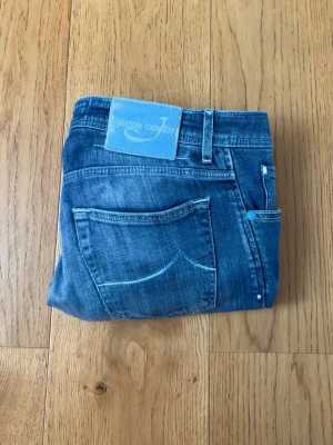 Jacob Cohen jeans - Snygga blå jeans från Jacob Cohen med klassisk femficksmodell och ljusblåa kontrastsömmar. Jeansen har en rak passform och patch med logga bak i midjan. Tillverkade i mjukt denimtyg som ger en avslappnad look.