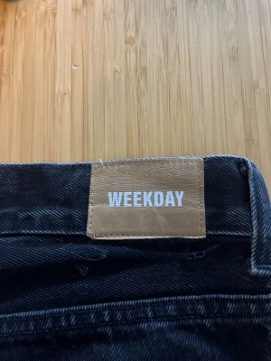 Svarta jeans från Weekday - Säljer ett par svarta jeans från Weekday i modellen Loose, med klassisk femficksdesign och raka ben. Jeansen är tillverkade i bomull och har en snygg tvättad finish. Perfekta för en avslappnad och trendig stil.