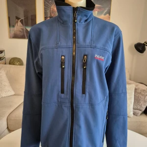 Peak Performance herrjacka * stl M - Snygg softshell jacka i blått från Peak Performance. Jättebra skick! * Alla dragkedjor är hela och det finns flera fickor.  * Hög krage * Gore windstopper membran. * Storlek M,  * Bröst: ca 55 cm mätt armhåla till armhåla * Nacke till ryggslut exkl krage: ca 66 cm * Innerärm: ca 56 cm. * Axlar, söm till som: ca 48cm.  Djur och rökfritt hem. Se bilder och förstora då de ingår i beskrivningen. Se gärna mina övriga annonser.   Vid avhämtning finns den i Sollentuna. 