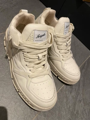 Vita sneakers från Axel Arigato - Vit/beige sneakers från Axel Arigato, storlek 42,5  har bara använts 1 gång annars ny