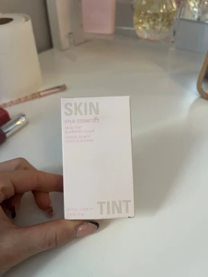 Kylie Cosmetics Skin Tint 2.5N - Skin Tint Blurring Elixir från Kylie Cosmetics i nyansen 2.5N. Kommer i en stilren, ljusbeige förpackning med minimalistisk design. Innehåller 30 ml flytande foundation som ger en naturlig finish och lätt täckning. Säljer då det var fel färg tyvärr 💕 skriv om ni undrar något !💕