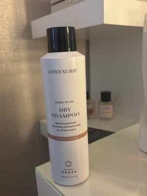 Löwengrip torrschampo Caramel & Cream - Torrschampo från Löwengrip i doften Caramel & Cream. Flaskan är vit med svart lock och har en stilren design. Produkten absorberar fett, ger volym och textur till håret och passar alla hårfärger. Perfekt för att fräscha upp håret snabbt. NYYYY