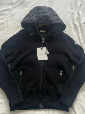 Moncler Cardigan - Säljer en helt ny moncler cardigan, med lappar och tags på. Den är i storlek L men passar mer som en M. (OBS 1;1 K0P1A) Pris kan diskuterras!