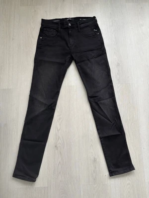 Svarta replay jeans - Säljer ett par svarta replay jeans med klassisk femficksmodell och dragkedjegylf. Jeansen har raka ben och diskreta sömmar, tillverkade i mjukt denimtyg med lite stretch för extra komfort. Perfekta för en stilren och avslappnad look. Dessa är anbass och är inte använda mer än 2 gånger. Hör av dig vid funderingar!