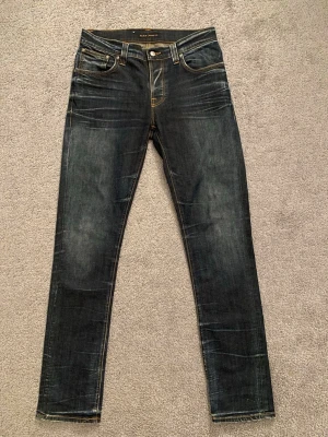 Nudie Jeans ”Grim Tim” - Säljer ett par grim tim blå jeans från Nudie Jeans med snygga fades. W33 L34. (Knappt använda)