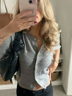 Grå kortärmad kofta med pärlknappar - Snygg grå kofta med korta ärmar och pärlknappar framtill. Storlek 158/164 passar xs🥰💗