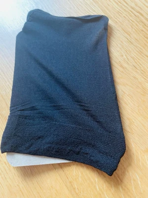 Perukmössa svart  - Perukmössa i stretchigt material. Perfekta att använda under peruken som skydd. Materialet är mjukt och följsamt, och färgen är klassiskt svart. Finns även i natur färg.