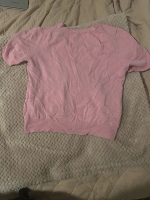 Rosa kortärmad topp från Zara - Söt rosa topp från Zara med korta ärmar och rund hals. Tillverkad i mjukt material som känns skönt mot huden. Perfekt att matcha med jeans eller kjol för en avslappnad look.