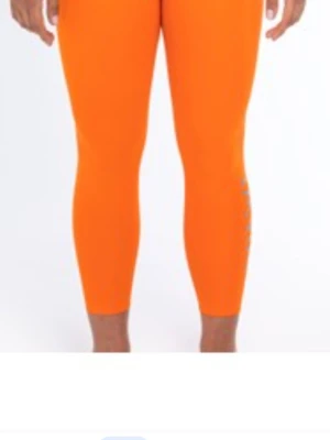 Orange croppade leggings. helt ny oanvänd  - Snygga och färgstarka orange leggings med croppad längd. Perfekta för dig som vill sticka ut och ha bekväma byxor till vardags eller träning. Tillverkade i stretchigt syntetmaterial för bästa passform. HELT NYTT OANVÄND 