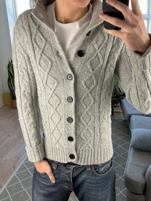 Stickad grå cardigan  - Unik och extremt snygg! Mått: A:48 B:45 C:41 D:66 (cm) nopprig annars bra skick. Skriv vid fundering 😊✌️