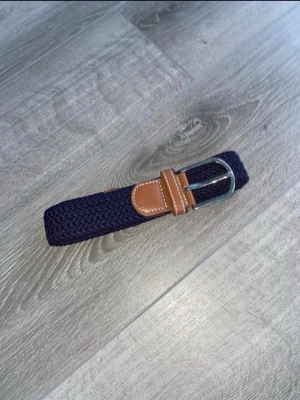 flätat bälte - Stilrent mörkblått flätat bälte. 105cm och elastiskt. Aldrig använt