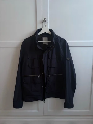 J.Lindeberg Field Jacket - Tjena! Säljer nu min snygga field jacket från J.Lindeberg. Jackan är i fint skick och har inga skavanker. Storleken är L. Modellen på bilden är 185. Mitt pris är 750kr. Hör av dig om du har någon fråga!