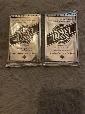 Upper Deck NHL Hockeykort 1992-93 - Två oöppnade paket NHL hockeykort från Upper Deck, säsongen 1992-1993. Varje paket innehåller 15 samlarkort med holografiska detaljer. Silverfärgade förpackningar, perfekt för samlare eller hockeyfans.