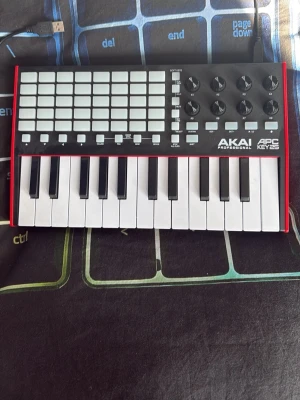 Akai APC Key 25 MIDI-kontroller - Säljer en Akai Professional APC Key 25 MIDI-kontroller med 25 tangenter, 40 pads och åtta rattar. Svart ovansida med vita tangenter och pads, samt röda sidor och undersida. Perfekt för musikproduktion och liveframträdanden. Ansluts via USB.