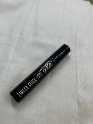 Got2b Tinted Glued Ögonbrynsgel brun - Säljer en Got2b Tinted Glued ögonbrynsgel i brun nyans. Perfekt för att forma och färga brynen med ett naturligt resultat. Kommer i en smidig tub med svart lock och enkel applikator. Ger stadga och definition till brynen.