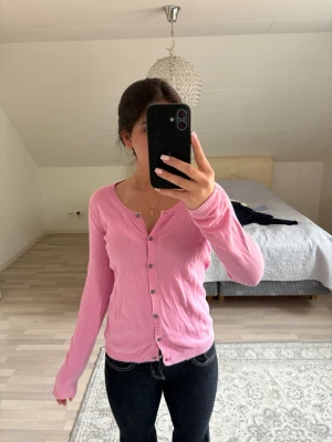 Rosa kofta från Tommy Hilfiger🩷 - Säljer en söt rosa kofta från Tommy Hilfiger. Den har långa ärmar och knappar framtill. Perfekt för att lägga till en färgklick i din garderob! Den har används väldigt mycket innan, men nu används den inte alls💗