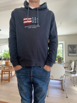 Mörkblå Lexington hoodie med brodyr - Mörkblå hoodie från Lexington med broderad amerikansk tryck. Bra skick inga defekter