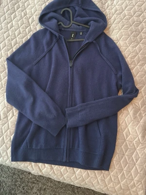 Mörkblå Kashmir zip hoodie - Mysig mörkblå hoodie med dragkedja från Ecoalf. Tillverkad av 70% återvunnen ull och 30% återvunnen kashmir. Klassisk modell med huva och ribbade muddar. Perfekt för en chill och stilren look. Är nästan oanvänd 10/10 skick