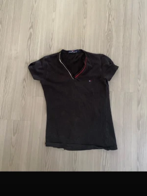 Svart v-ringad t-shirt Tommy Hilfiger - Säljer en svart och tight Tommy Hilfiger T-shirt för 60 kr. Tröjan är i fint skick! Och är i storlek M.