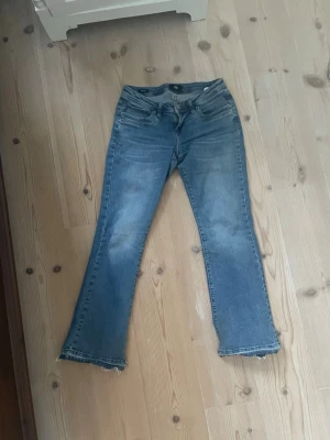 Blå bootcut jeans från LTB - Snygga blå bootcut jeans från LTB, modell Valerie. Jeansen har , dragkedjegylf och råa kanter nertill. Tillverkade i bomullsdenim med en lätt tvättad look och subtila slitningar för en cool vibe. Har sprättat upp dom nertill och de har blivit ganska slita där men inget som tänks så mycket på när de används 
