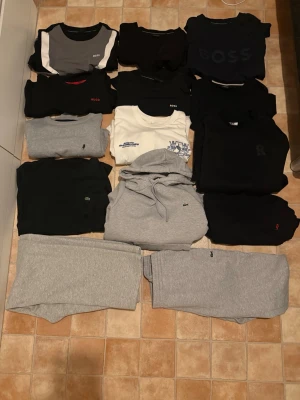 Mycket kläder  - 6 Hugo/boss t shirt, Lacoste hoodie byxor och t shirt samt byxor ifrån doubles. 2 mcs sweatshirt och 1 risky sweatshirt och även en t shirt ifrån Zara allt är storlek L förutom 1 t shirt med stort boss på bröstet och byxorna som inte är Lacoste är xl allt är i bra skick bara Lacoste hoodie och t shirt som är mycket använda. Säljs ej separat, har du fler frågor eller fundering skriv 