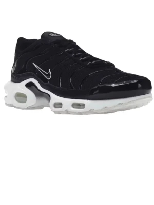 Svarta Nike Air Max TN sneakers - Säljer ett par svarta Nike Air Max TN sneakers med vit sula och klassisk Tn-detalj på hälen. Skorna har snörning, rund tå och synliga vågmönster på ovandelen. Perfekta för dig som gillar sportig och stilren look.